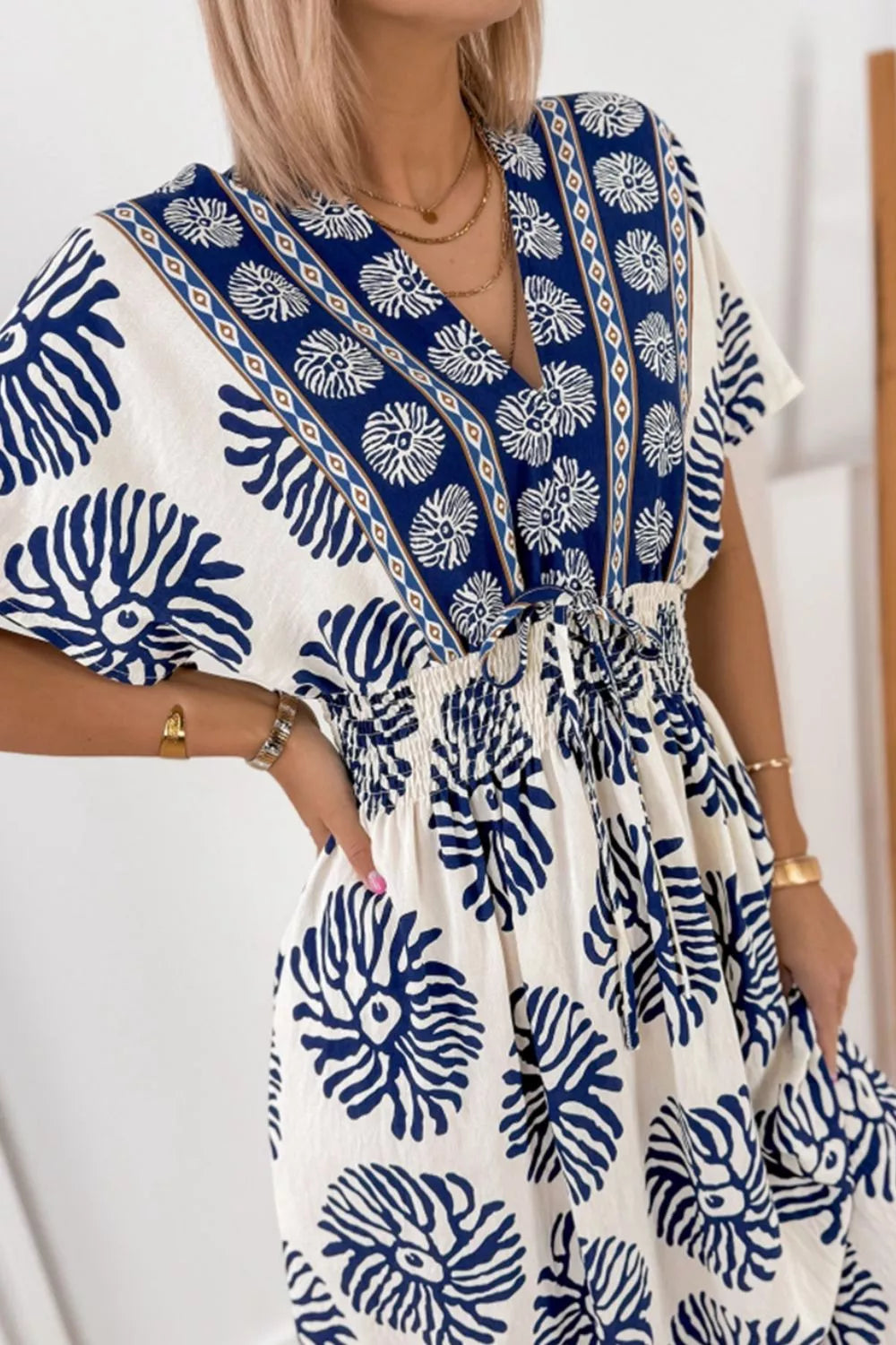 Floral print V-neck dolman dress close-up with gathered waist, blue-and-white