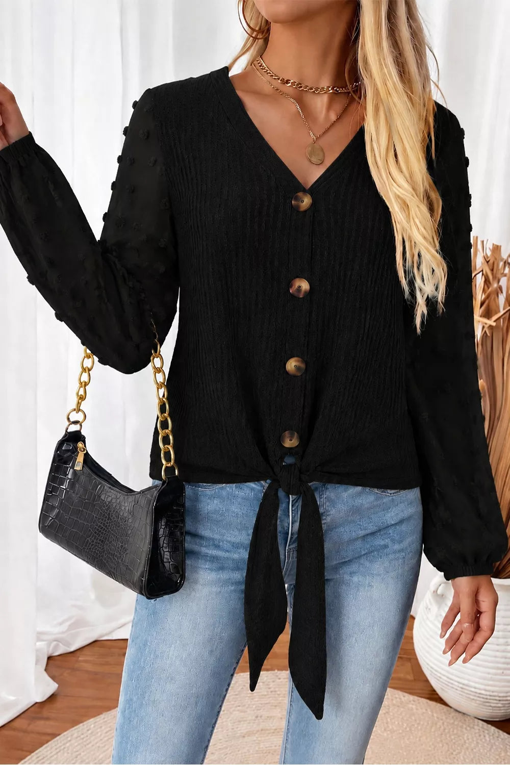 Black swiss-dot long-sleeve blouse with V-neck buttons and front tie hem