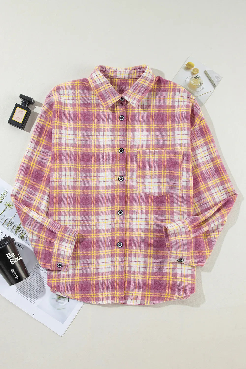 Pink plaid collared button-up shacket laid flat, with chest pockets