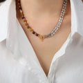 Beaded necklace with multicolor round stones and silver-tone chain on a white shirt
