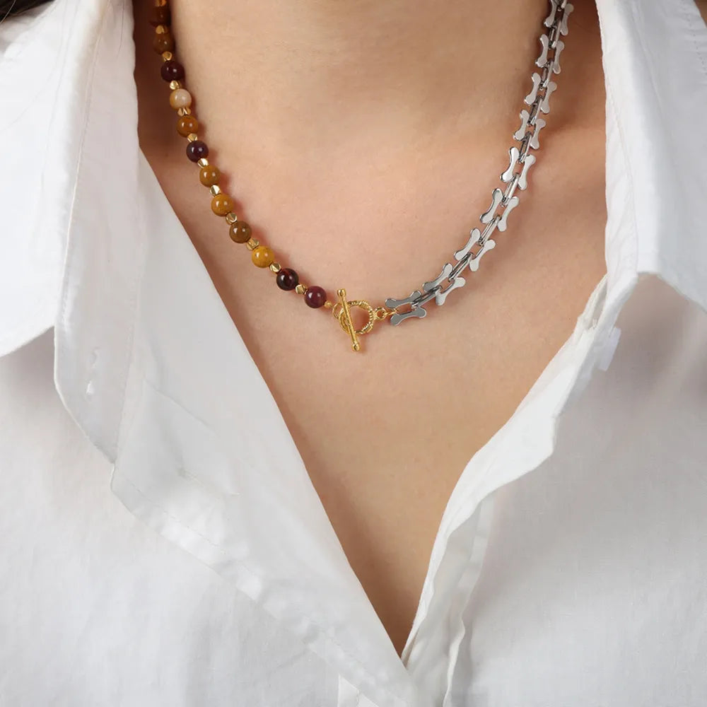Beaded necklace with multicolor round stones and silver-tone chain on a white shirt