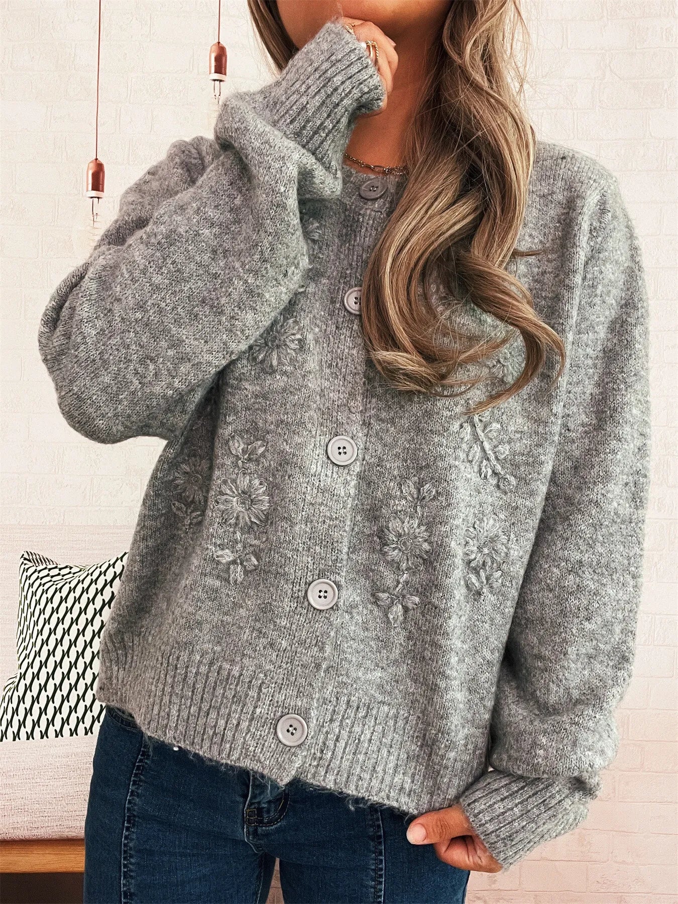 Gray knit cardigan with flower embroidery, three-button placket, ribbed hem and cuffs.