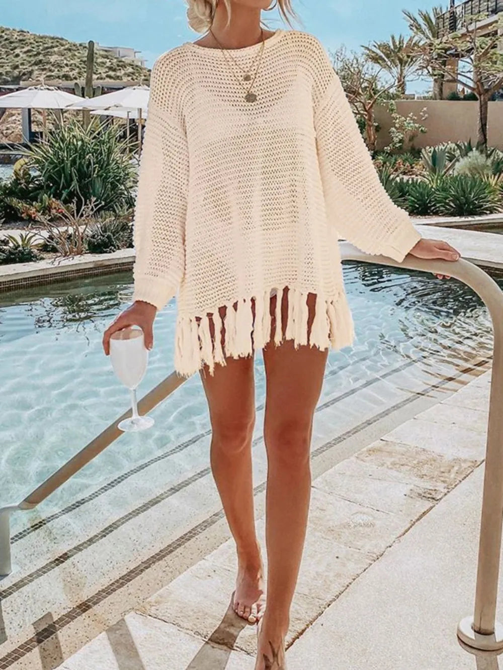 Cream openwork knit cover-up with long sleeves and tassel fringe hemline