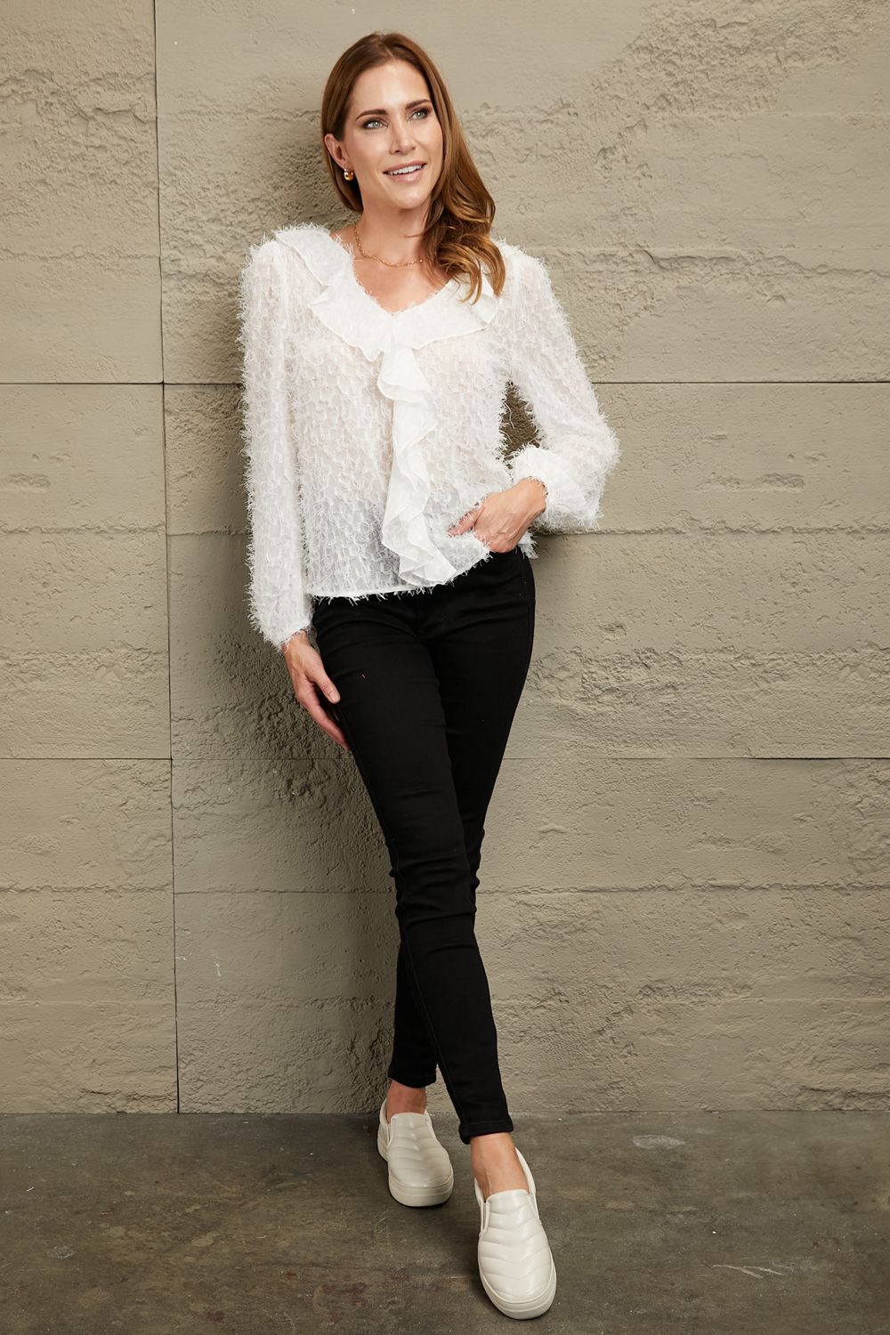 White ruffle-trim blouse with V-neck, fringe hem, and long balloon sleeves