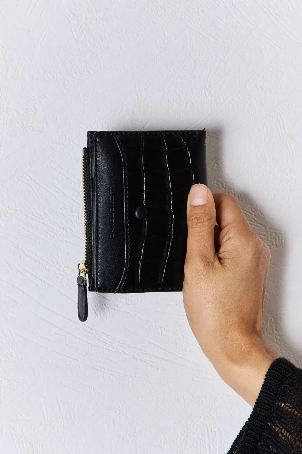 Black textured vegan leather mini wallet with front stitching and zip pull tab