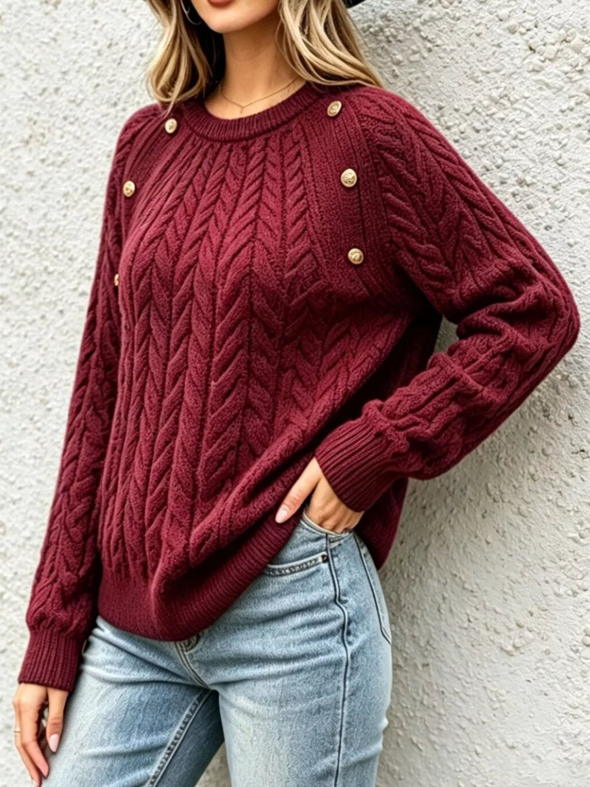 Deep red cable-knit raglan sweater with buttoned shoulders and ribbed hem