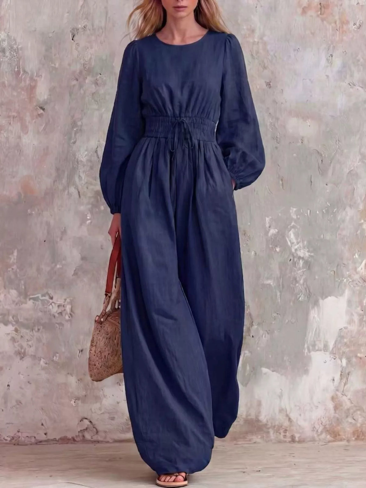 Smocked waist long-sleeve jumpsuit in dark blue, full-length wide-leg silhouette
