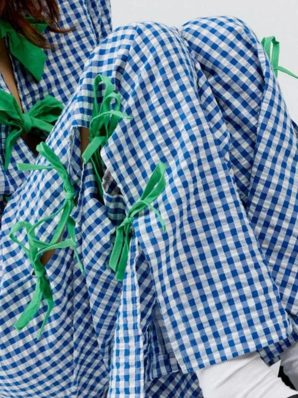 Blue plaid pants with green side ribbon ties, side view close-up