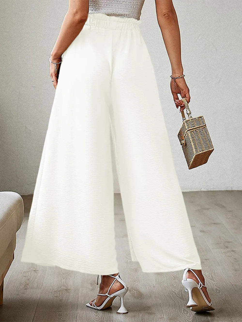 White tied-waist wide-leg pants with draped fabric and gathered waistband