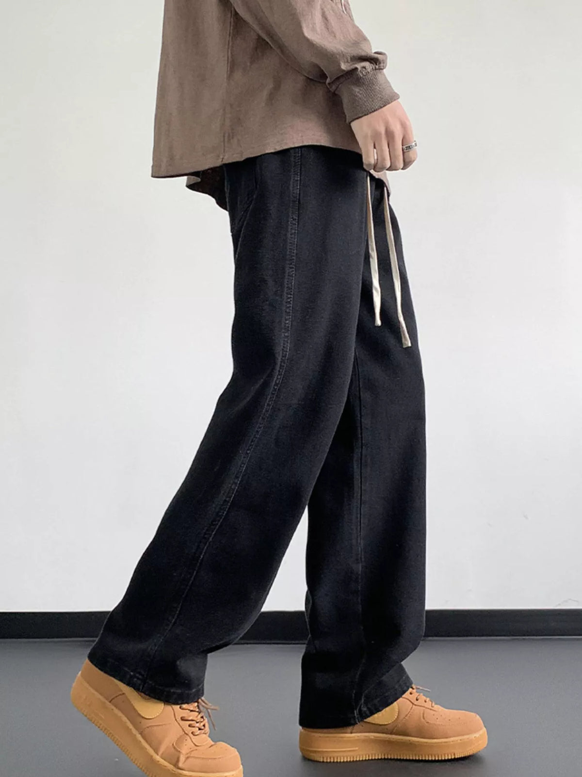Black washed denim jeans with relaxed fit, wide legs, and drawstring closure