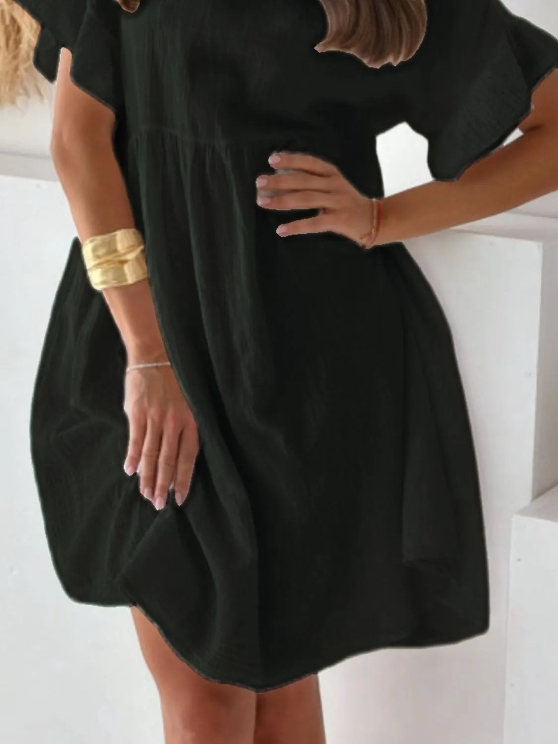 Black round-neck short-sleeve mini dress with a loose, drapey silhouette.