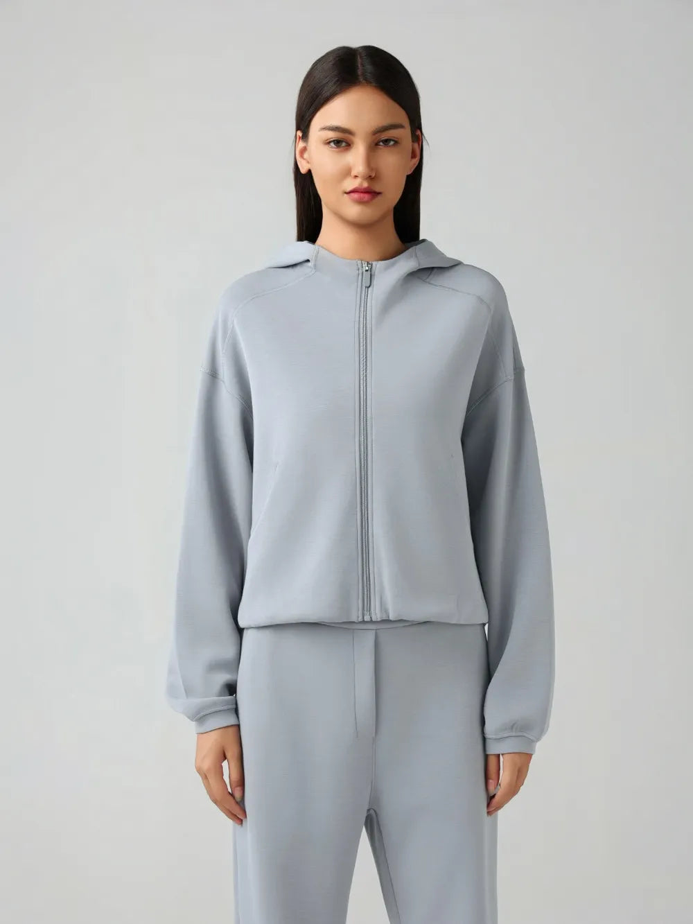 Light blue zip-up hooded jacket with full zipper and dropped shoulders, long sleeves