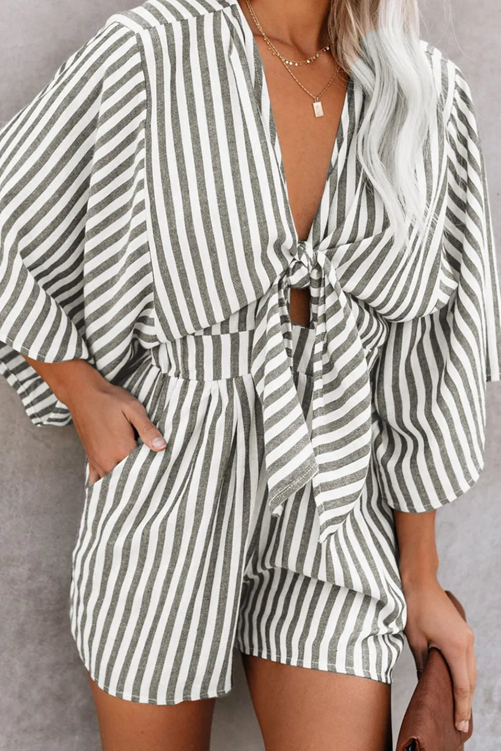 Striped kimono-sleeve romper with V neckline, waist tie, and ruffled waist, dark stripes