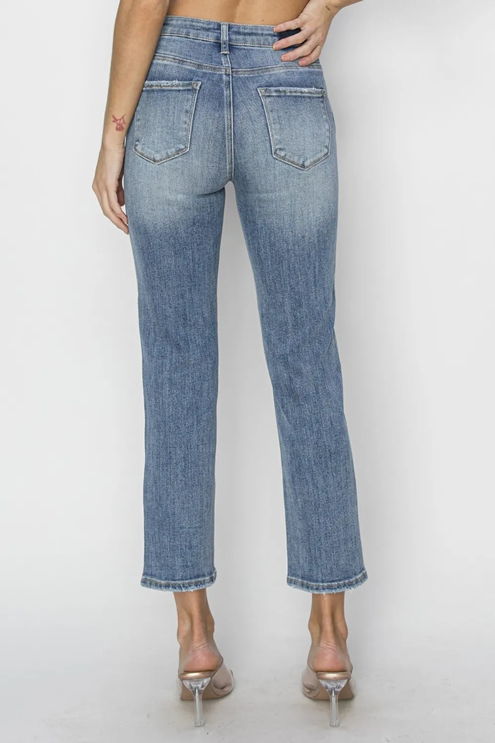 High-waist medium-wash cropped jeans with back patch pockets and distressed cuffs.