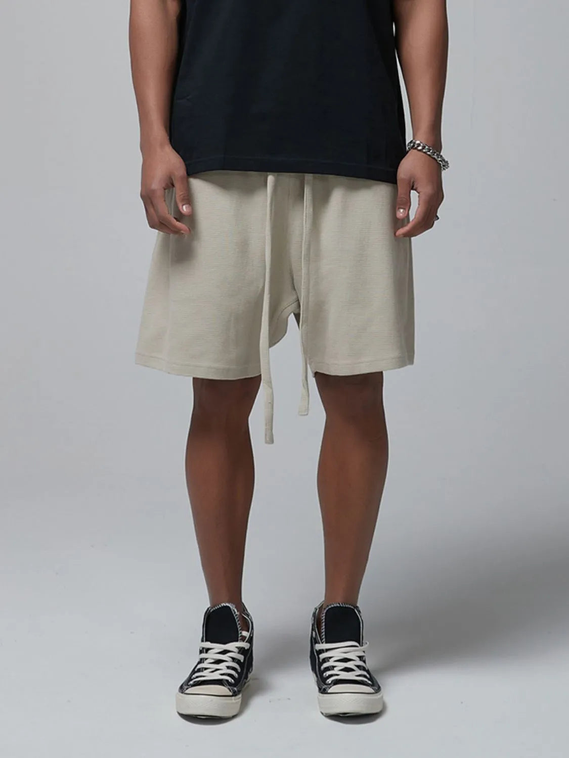 Men's beige waffle shorts with drawstring tie and side pockets, knee-length