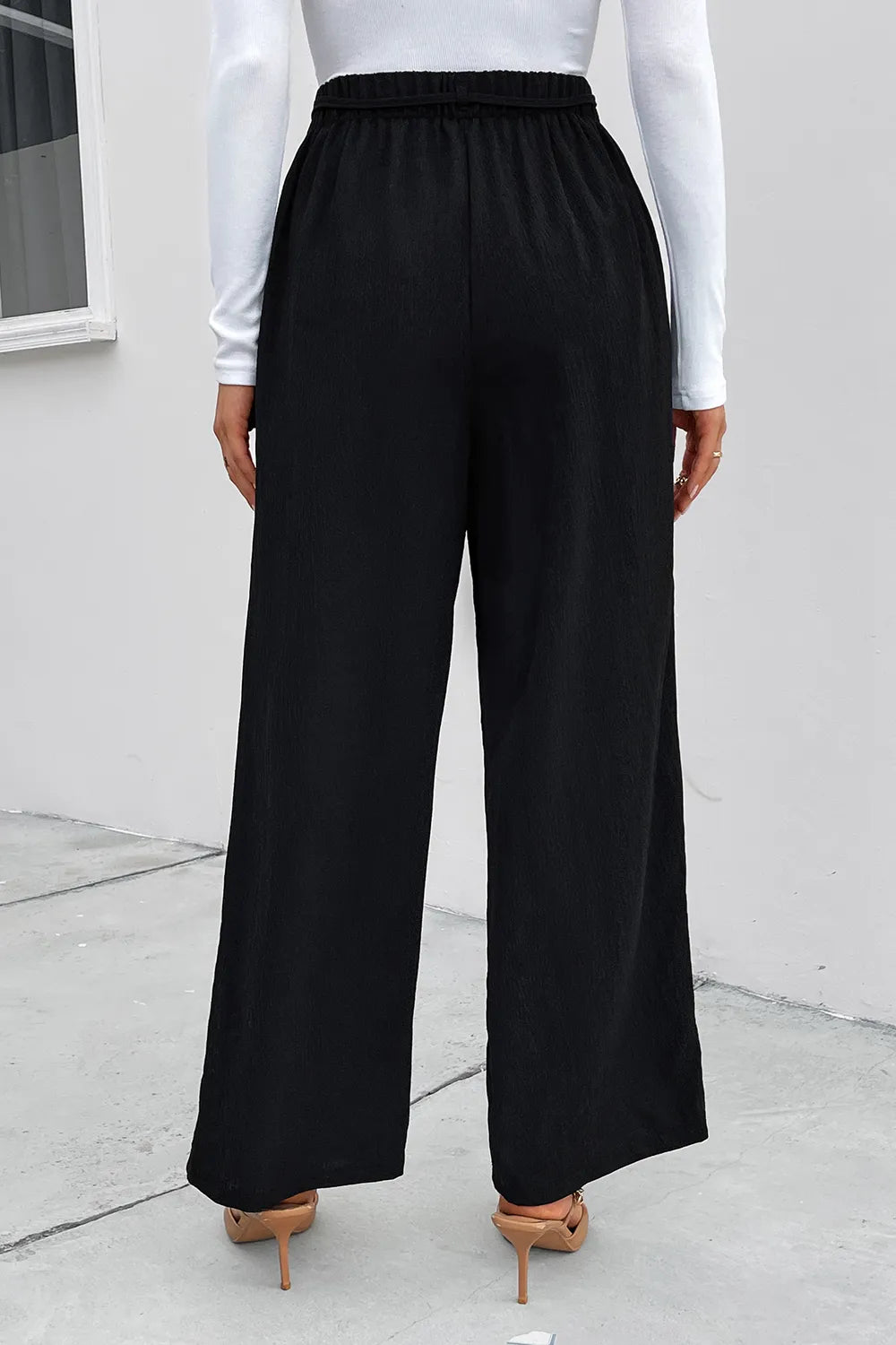 Black wide-leg pants with elastic waistband, back view