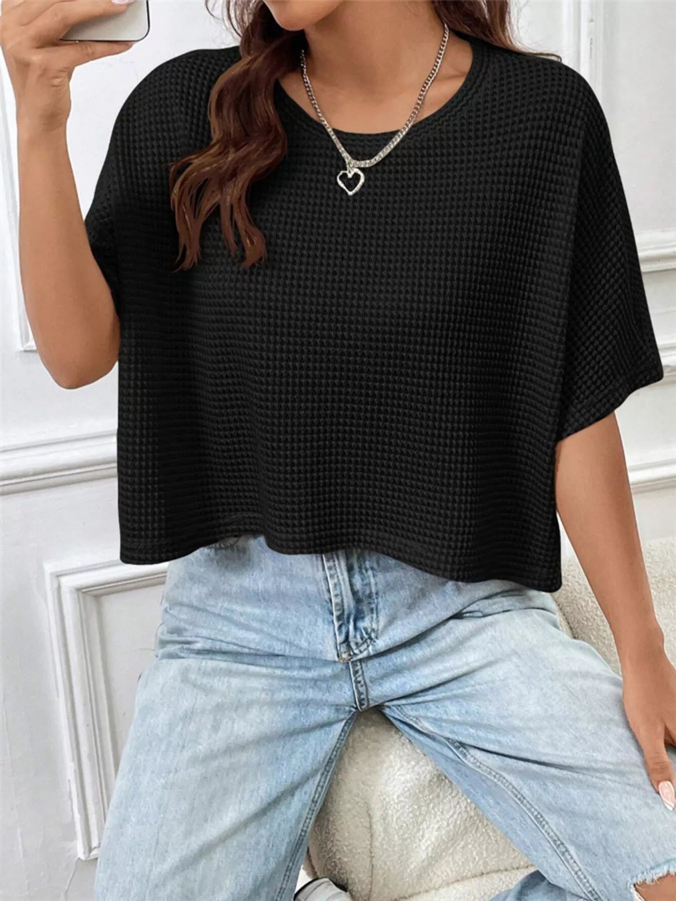 Black waffle-knit cropped t-shirt with crew neck and short loose sleeves.