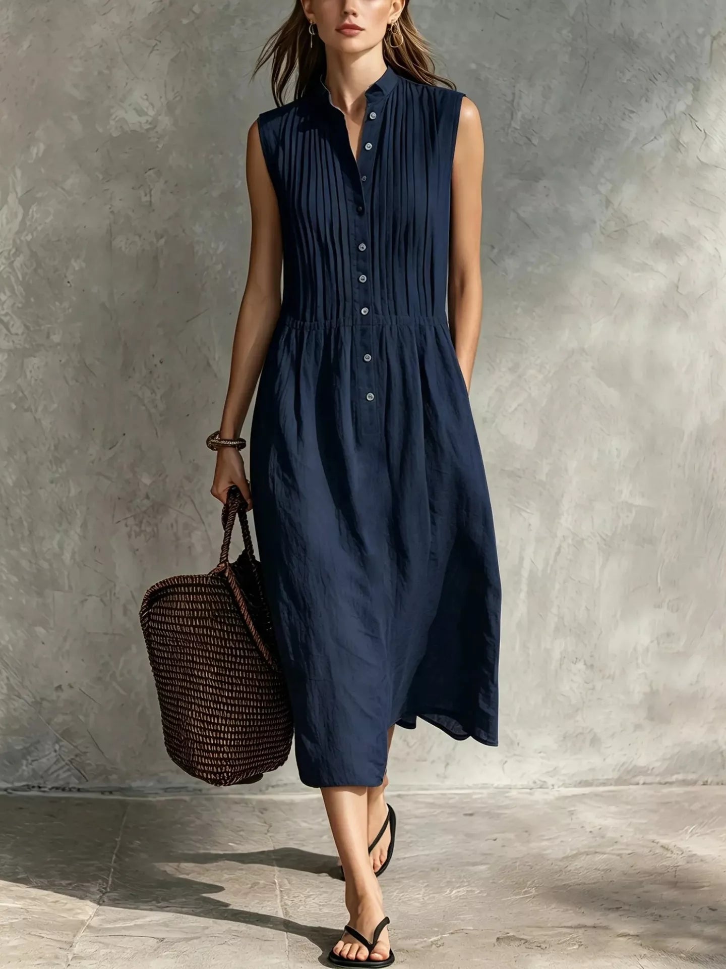 Dark navy sleeveless midi dress with front buttons, vertical pintuck panels, gathered waist