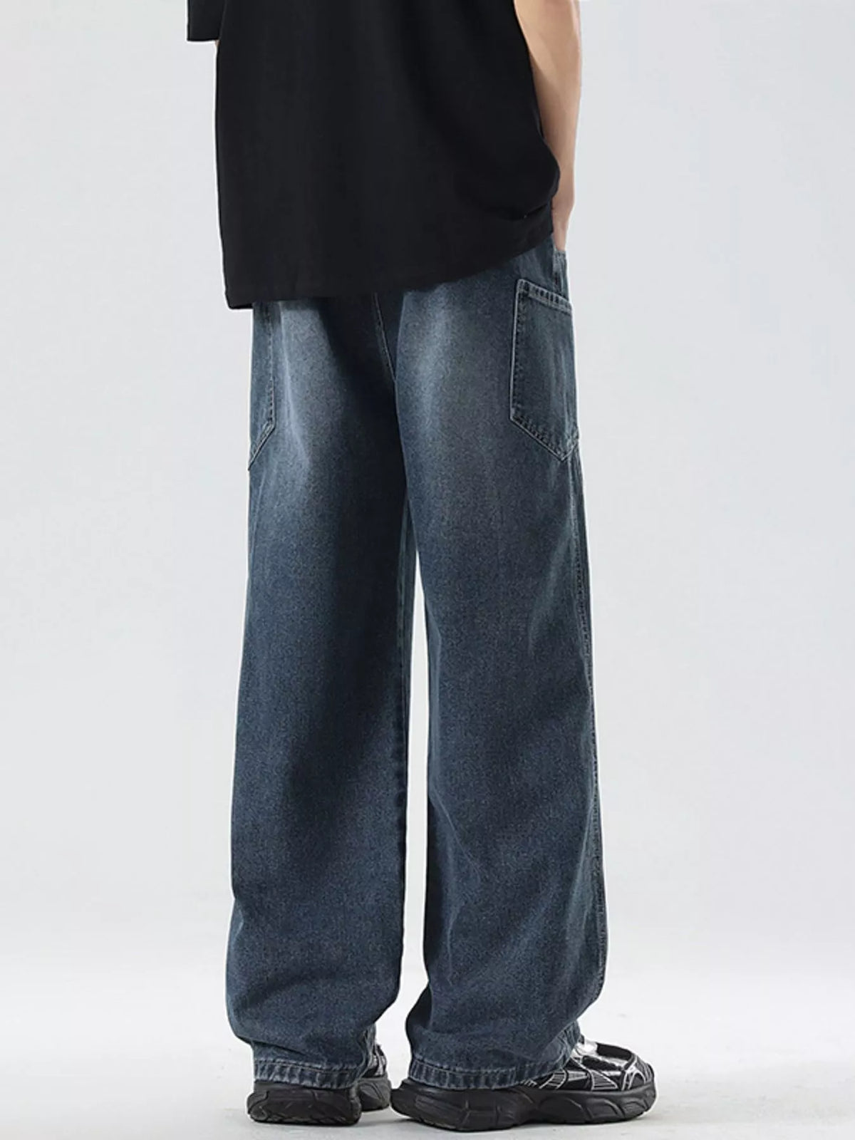 Men's vintage wide-leg jeans in dark blue denim, oversized straight legs, cuffed hem.