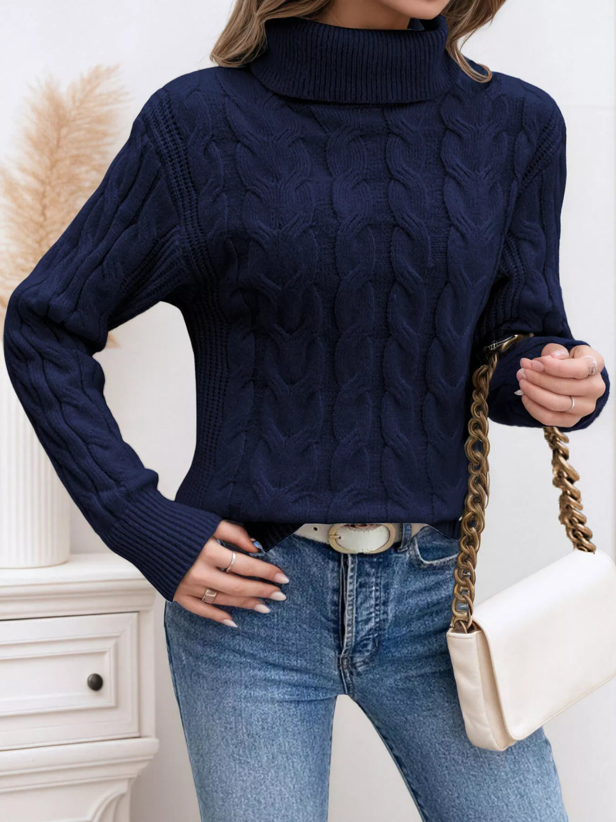Navy cable knit turtleneck sweater with long sleeves and thick cable knit texture