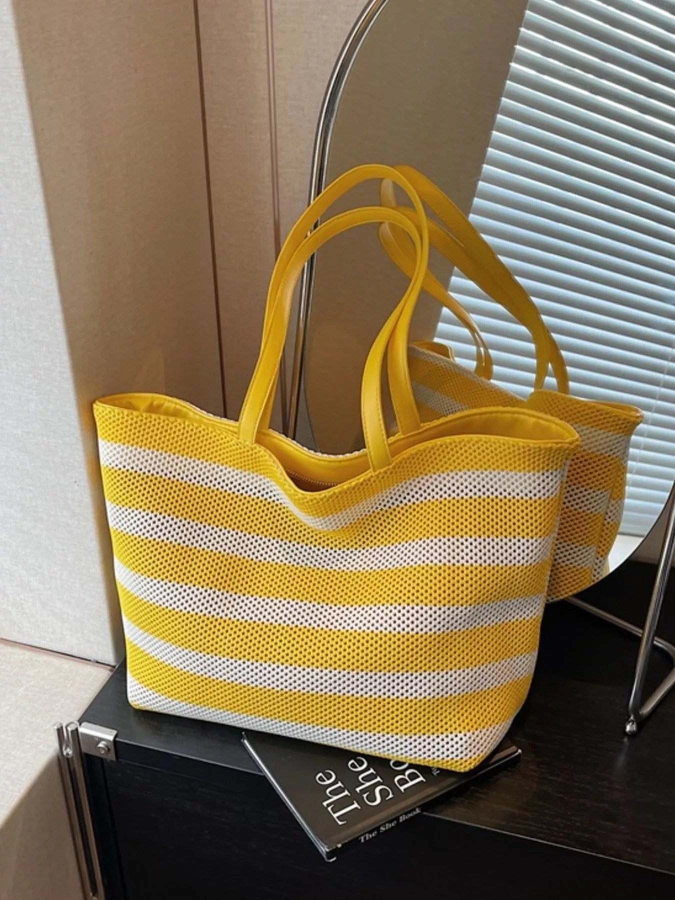 Yellow and white striped mesh shoulder tote with long handles and open top