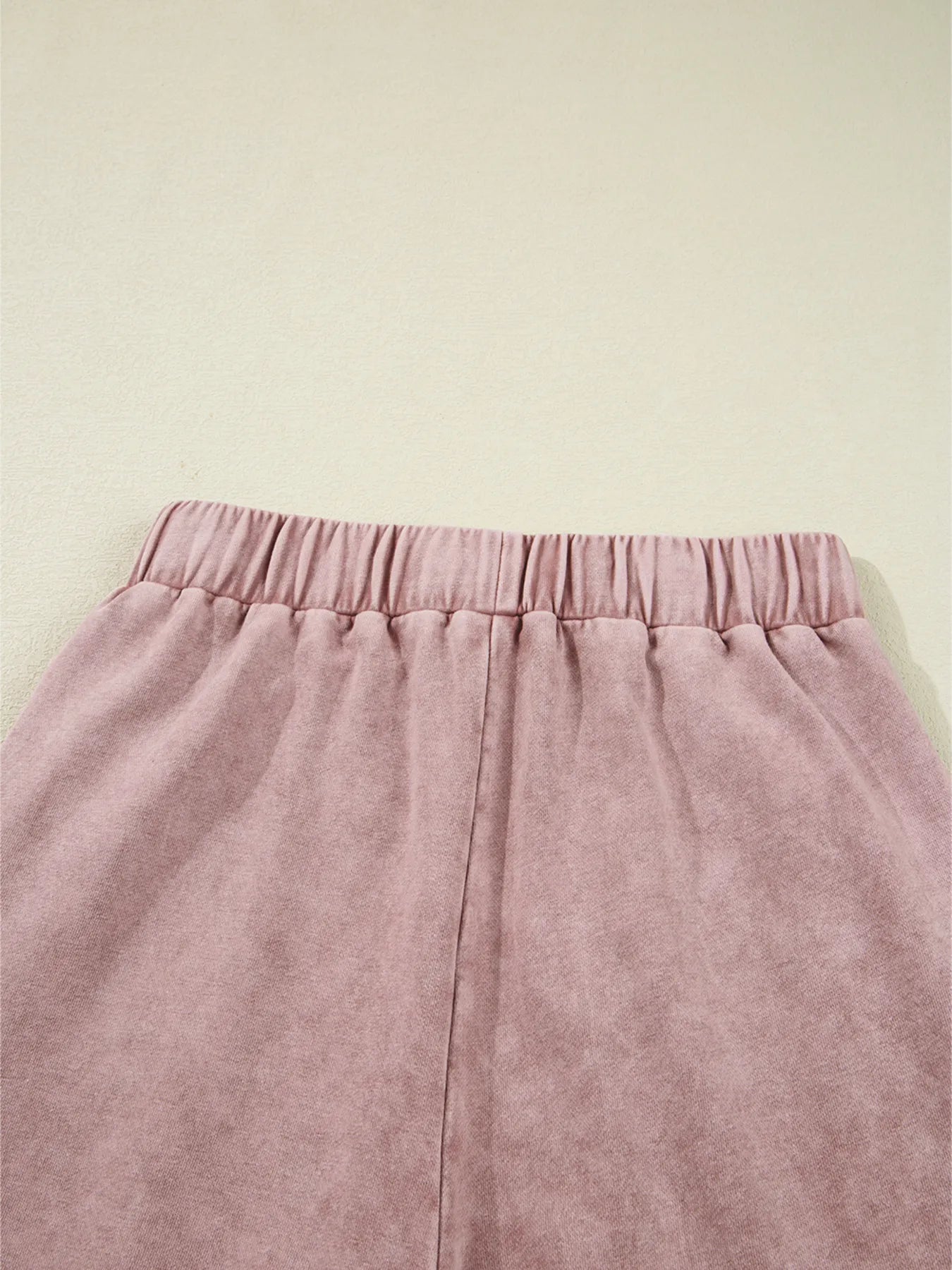 Dusty pink tiered wide-leg pants with gathered elastic waistband and seam details