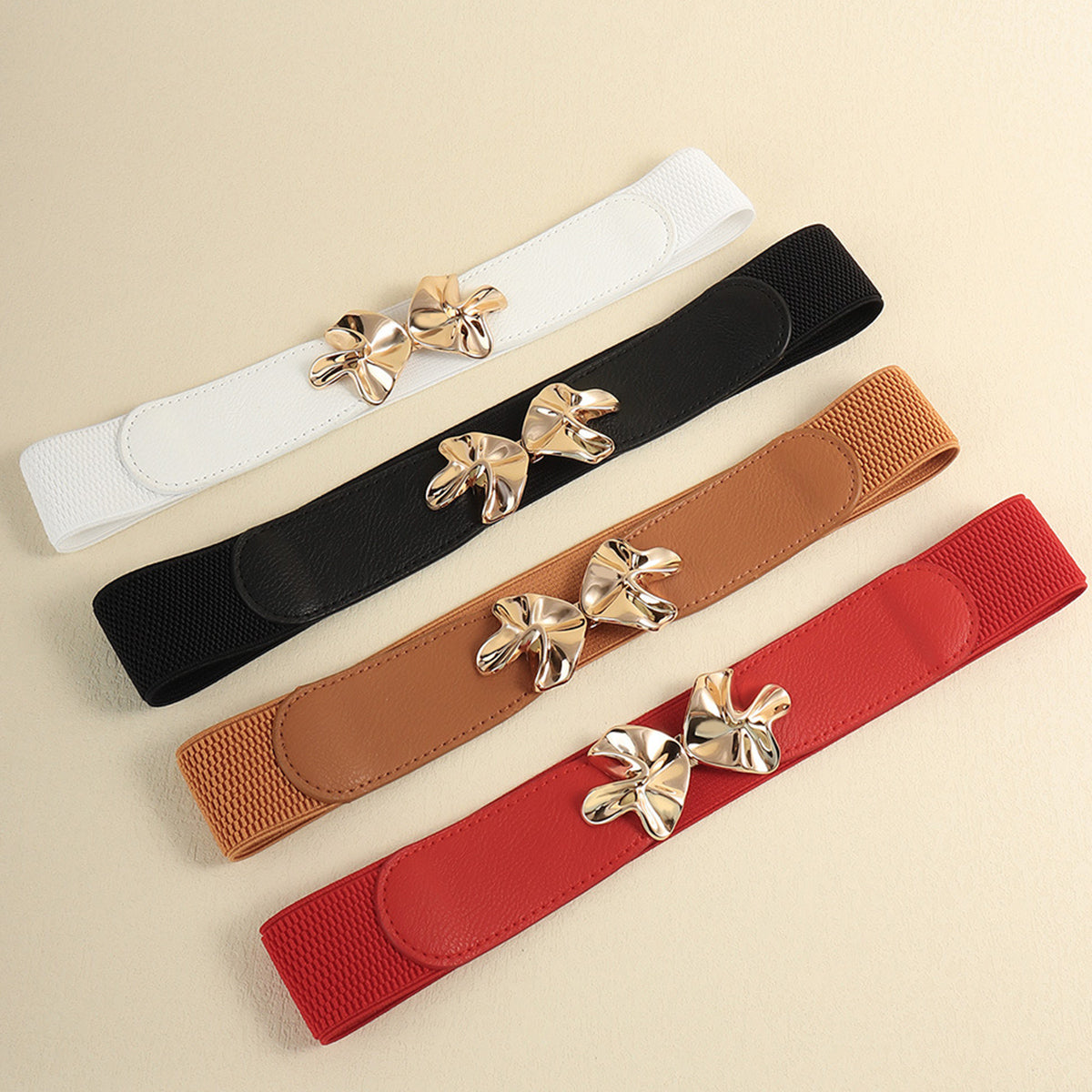 Assorted alloy buckle elastic belts: ivory, black, caramel, and red with gold bow buckle