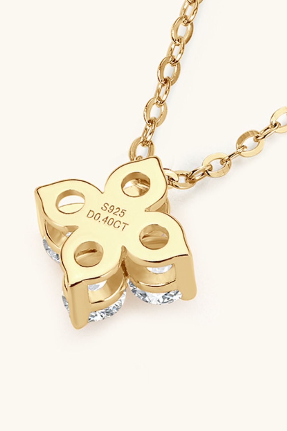 Gold-tone clover pendant necklace with four round stones and “S925” stamped on the charm