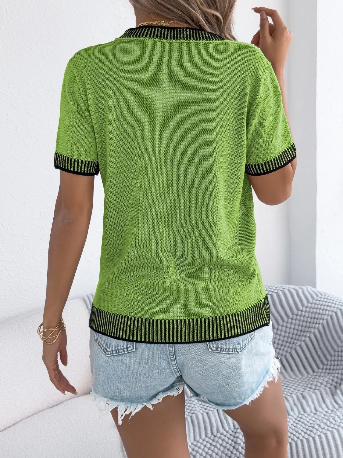 Green round-neck short-sleeve knit top with black ribbed collar and cuffs, back view