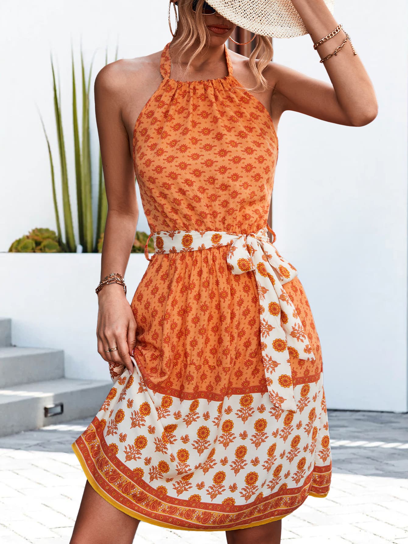 Orange floral halter neck dress with tie waist bow, tiered skirt and white patterned hem