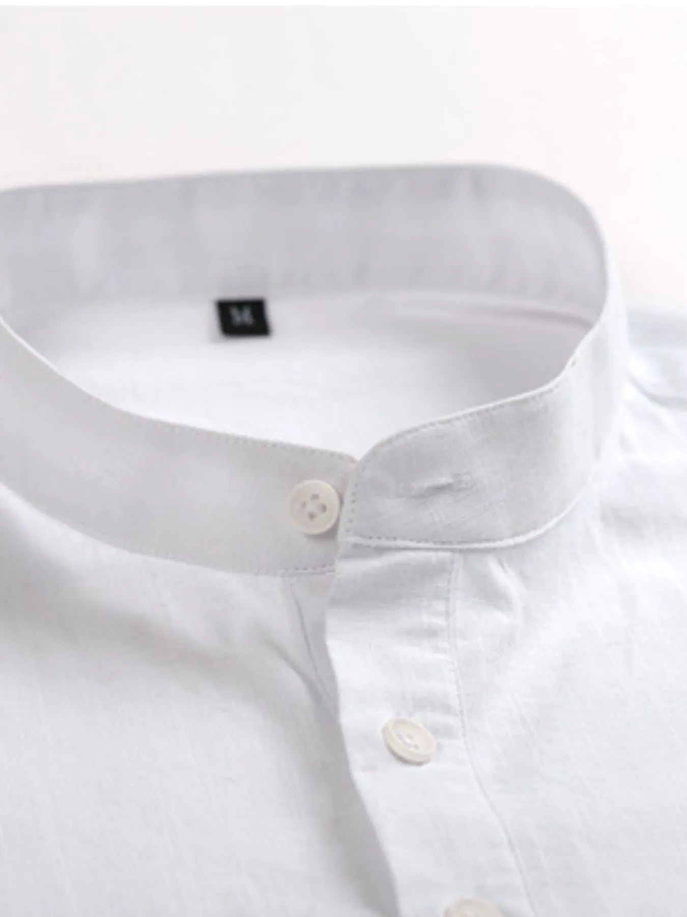 Men's mandarin collar shirt in white, close-up of buttons and stand collar