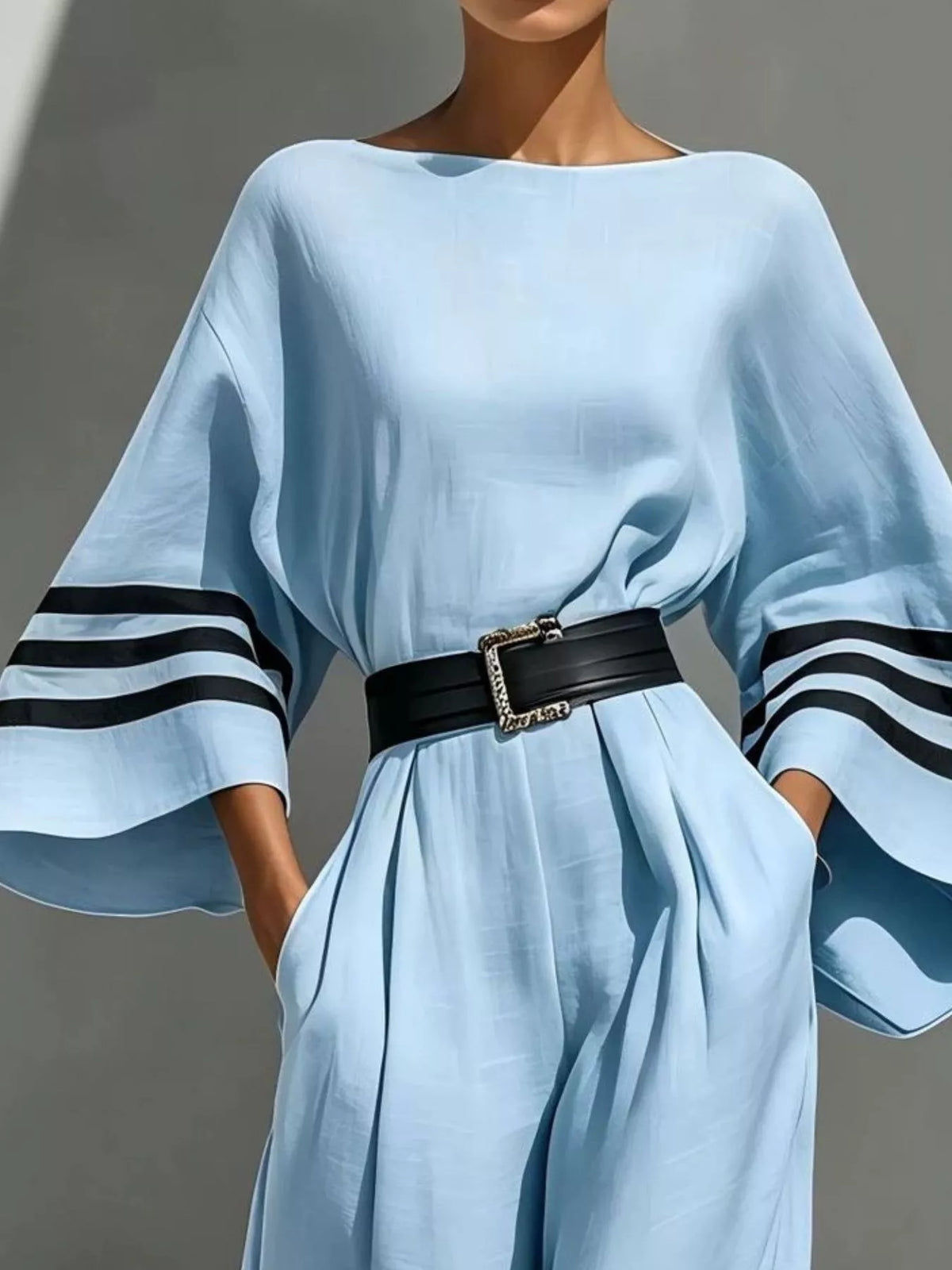 Light blue jumpsuit with striped sleeve cuffs and cinched waist belt