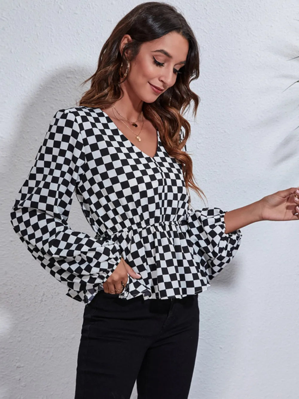 Checkered V-neck peplum blouse with balloon sleeves and elastic cuffs, black and white