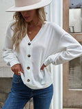 White V-neck dropped-shoulder blouse with front button placket and long sleeves