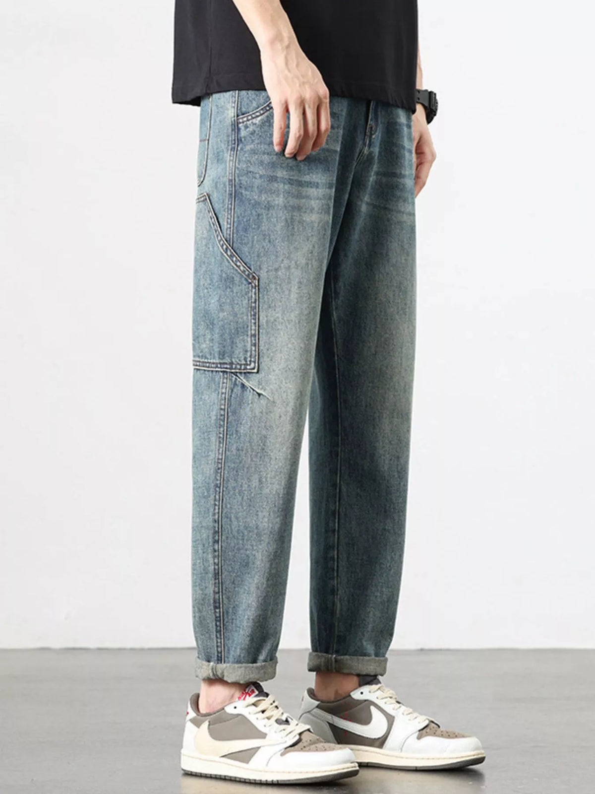 Washed blue relaxed jeans with side patch pocket and cuffed hem.