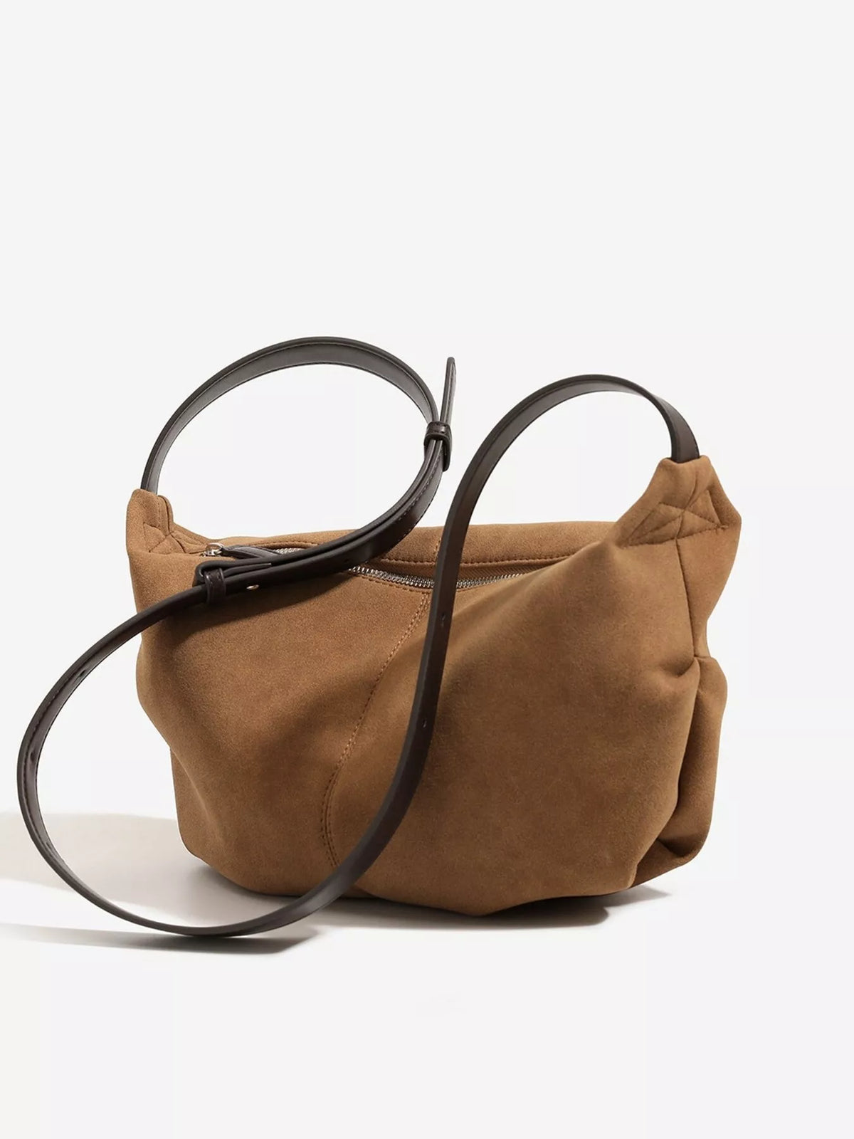 Brown suede crescent shoulder bag with long black shoulder strap and side seam