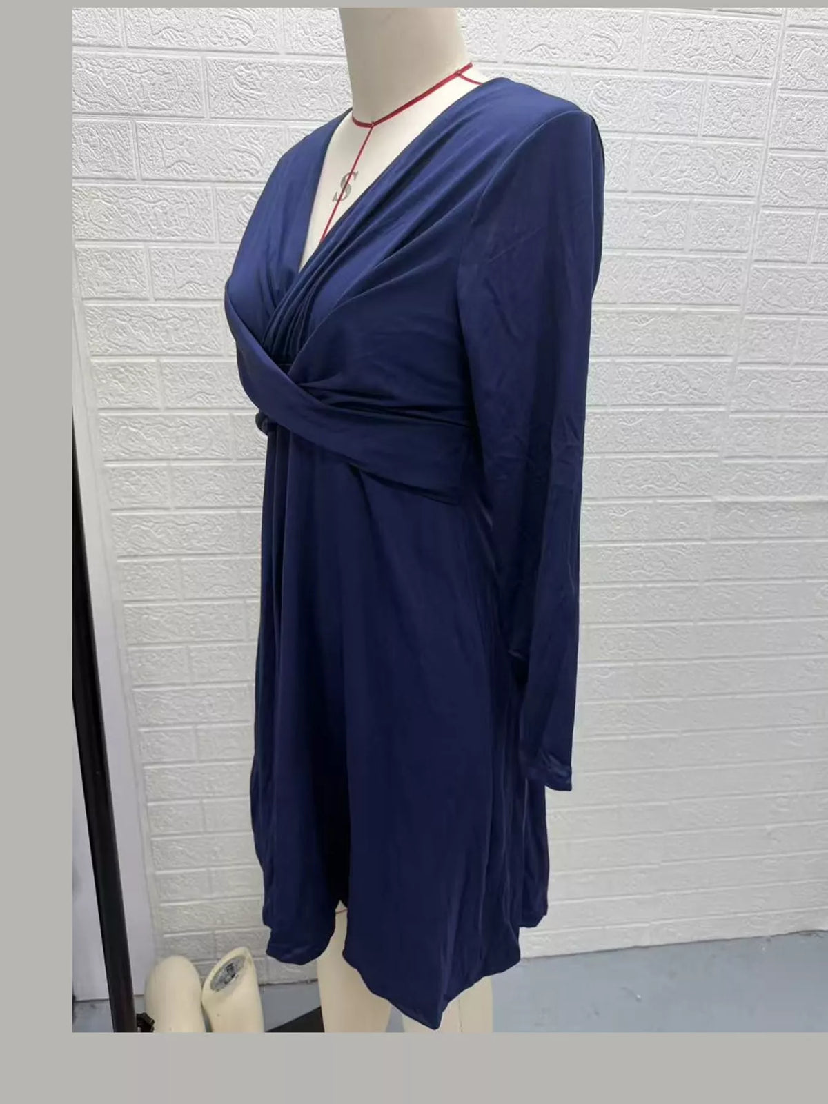 Navy blue long-sleeve midi dress with wrap V neckline and gathered waist.