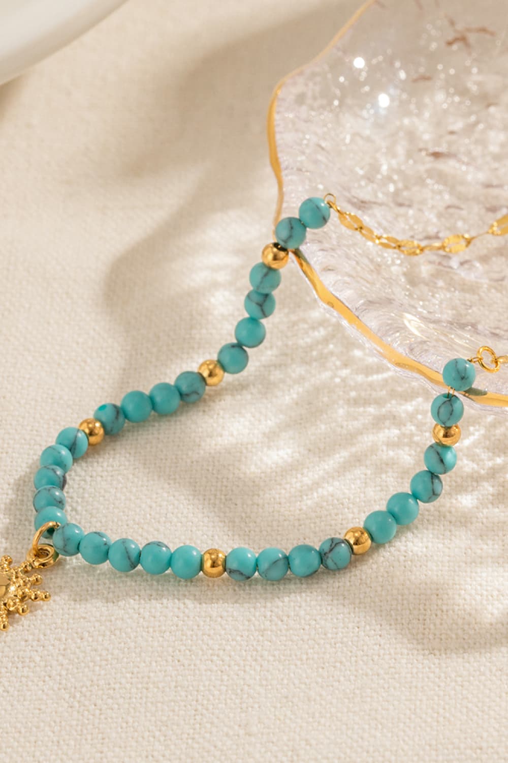 Turquoise beaded gold link necklace with small sun charm detail