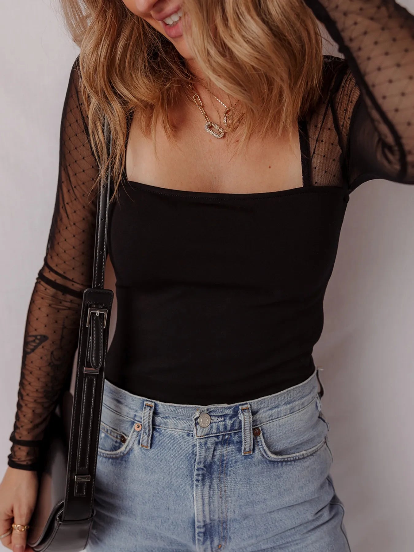 Black square-neck bodysuit with sheer dotted mesh sleeves and fitted stretch silhouette
