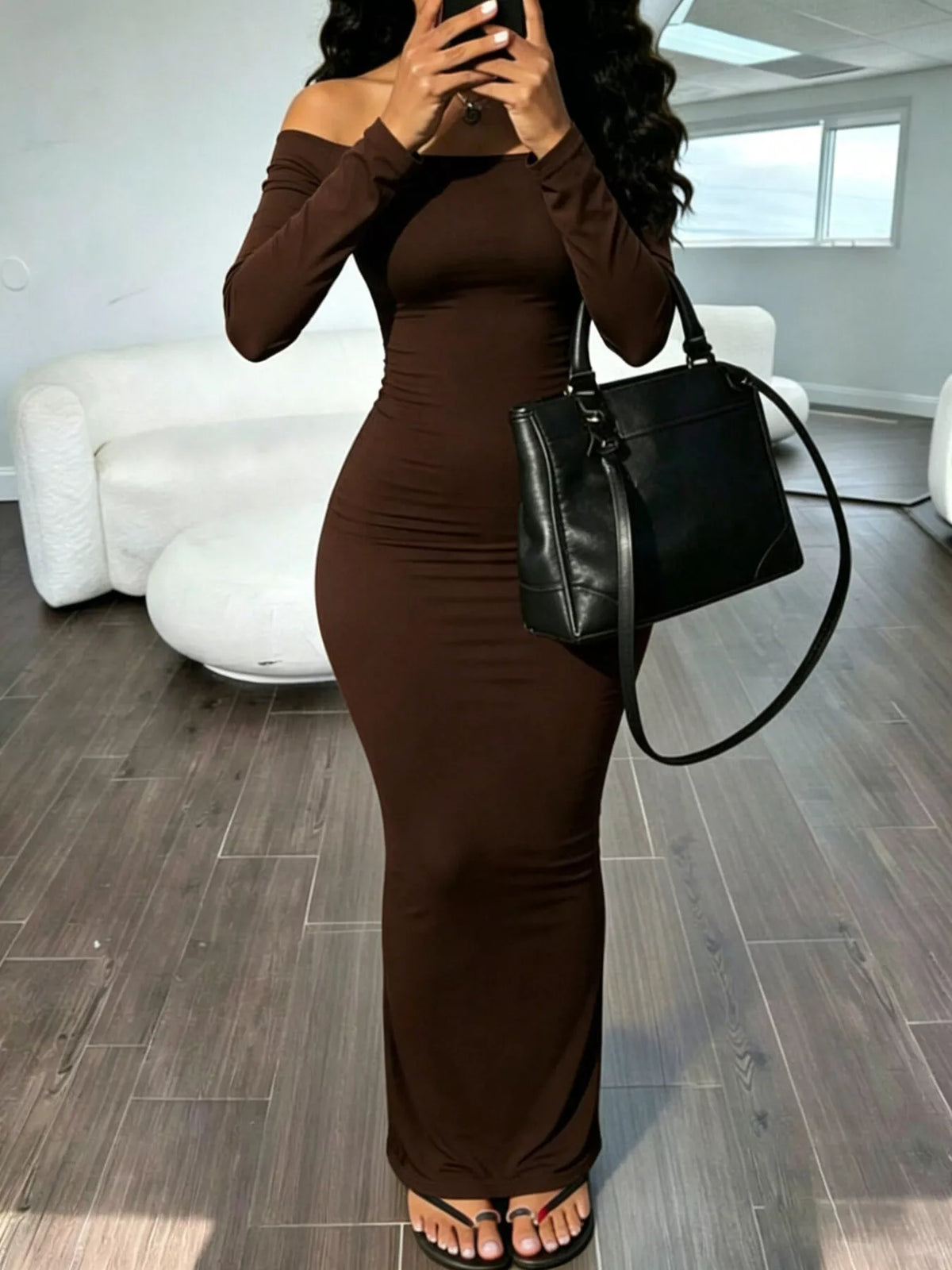 Brown off-shoulder fitted maxi dress with long sleeves, ruched hip detail.