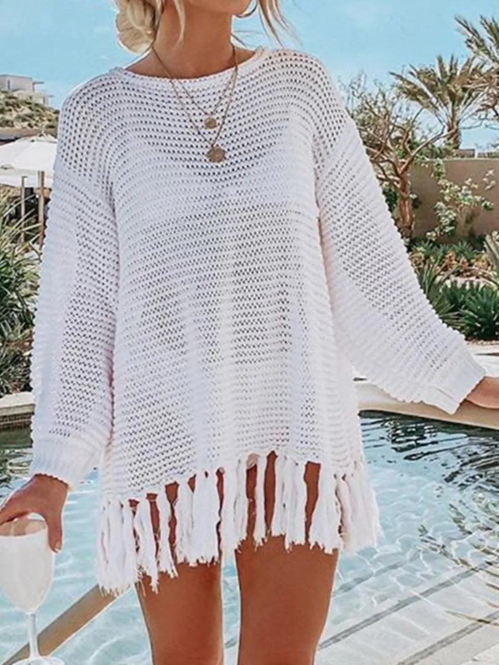 White long-sleeve openwork knit cover up with tassel fringe hem.
