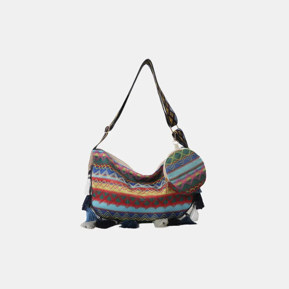 Printed hobo crossbody bag with multicolor zigzag stripes and tassel fringe.