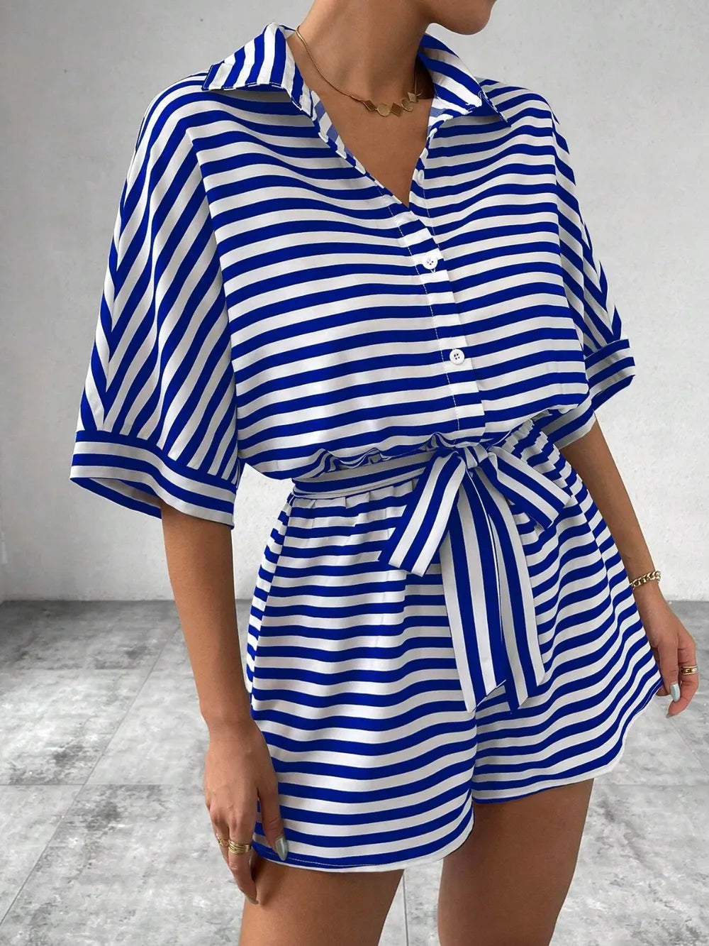 Blue-and-white striped tie-waist romper with half-button V-neck and short sleeves