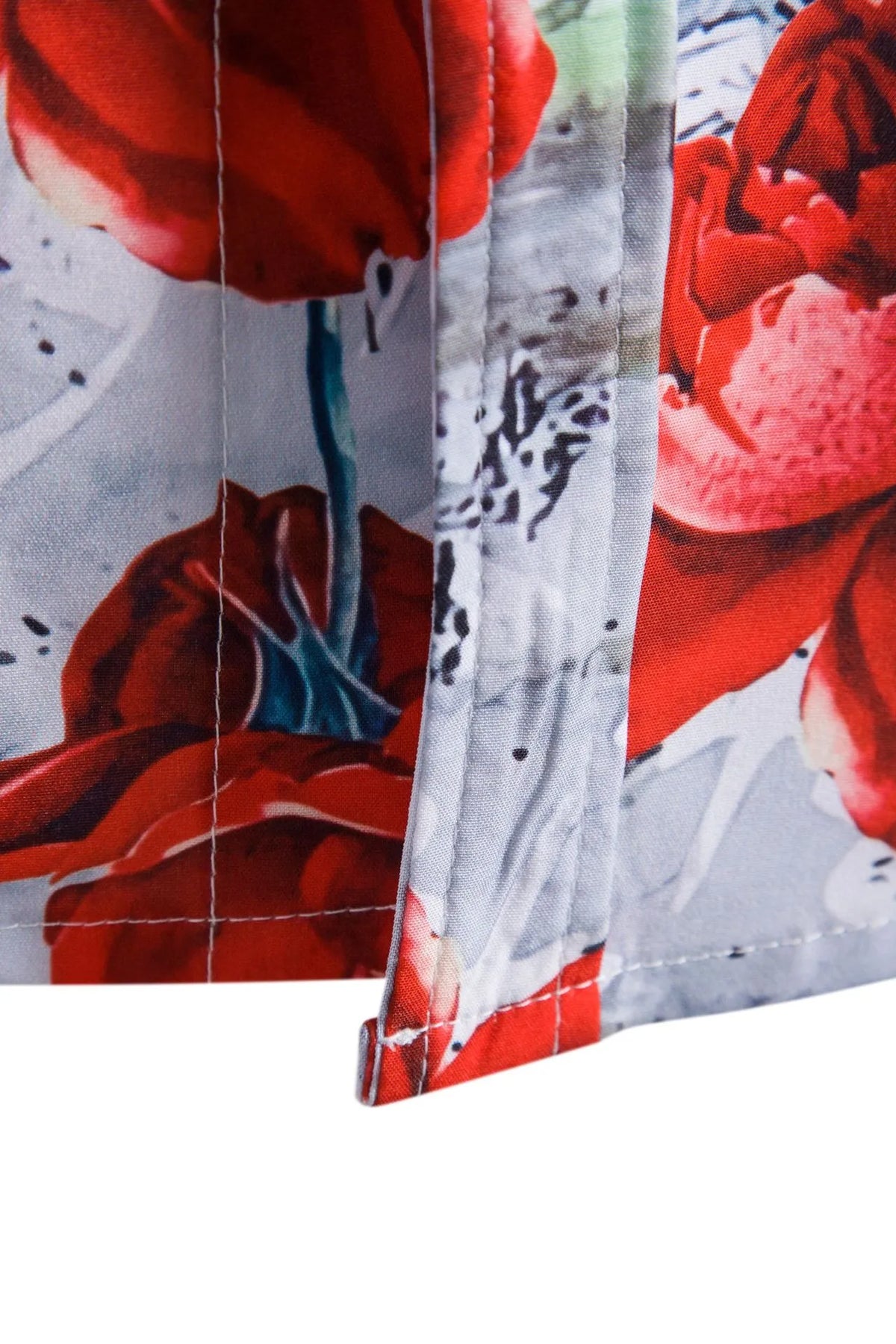 Floral button-up shirt hem and side seam, red rose print on white