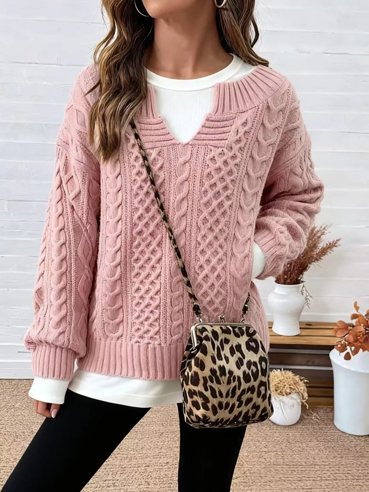 Dusty pink cable knit sweater with dropped shoulders, V-neck, and ribbed trim
