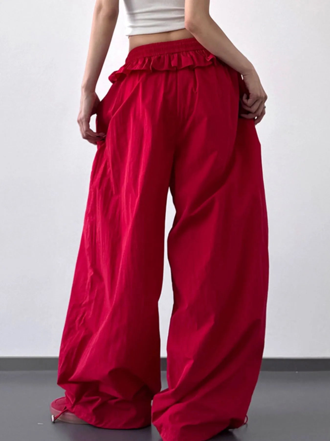 Red drawstring wide-leg pants with ruffled waistband and wide draped legs
