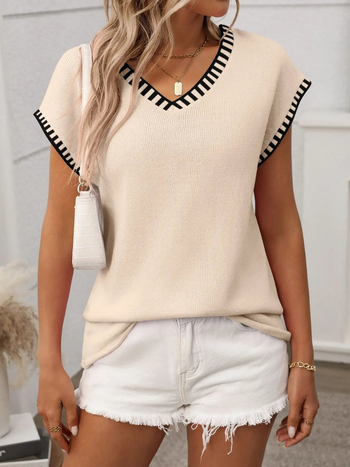 Tan knit V-neck top with black contrast-trimmed short sleeves