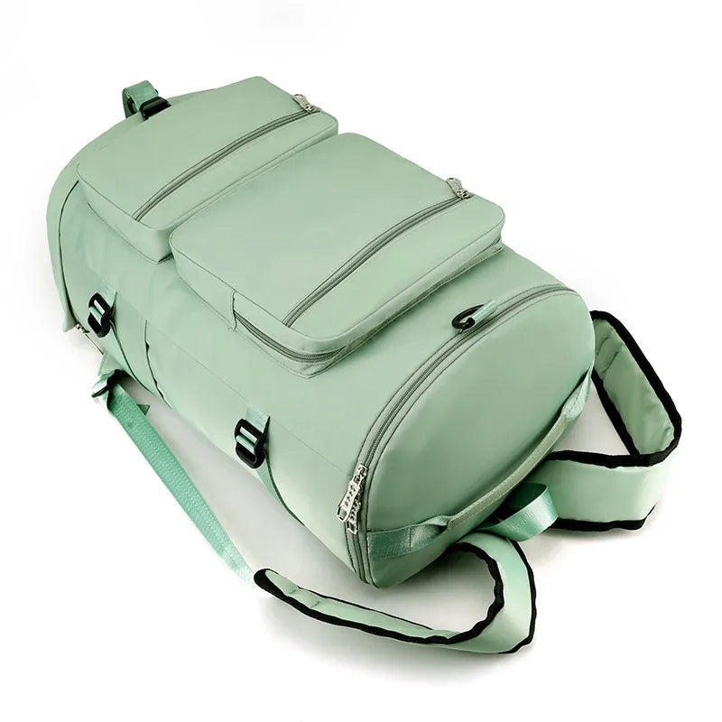 Mint green large travel backpack with layered top flap, multiple zip pockets, and carrying strap.