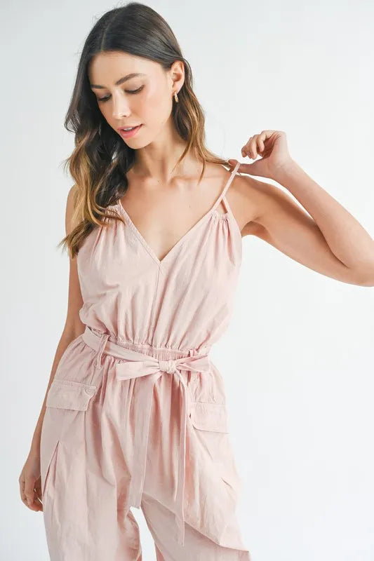 Pink spaghetti strap jumpsuit with tied waist belt and loose gathered fabric