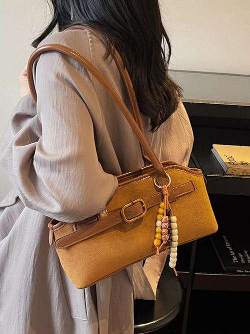 Brown suede shoulder bag with front buckle strap and beaded fringe charm